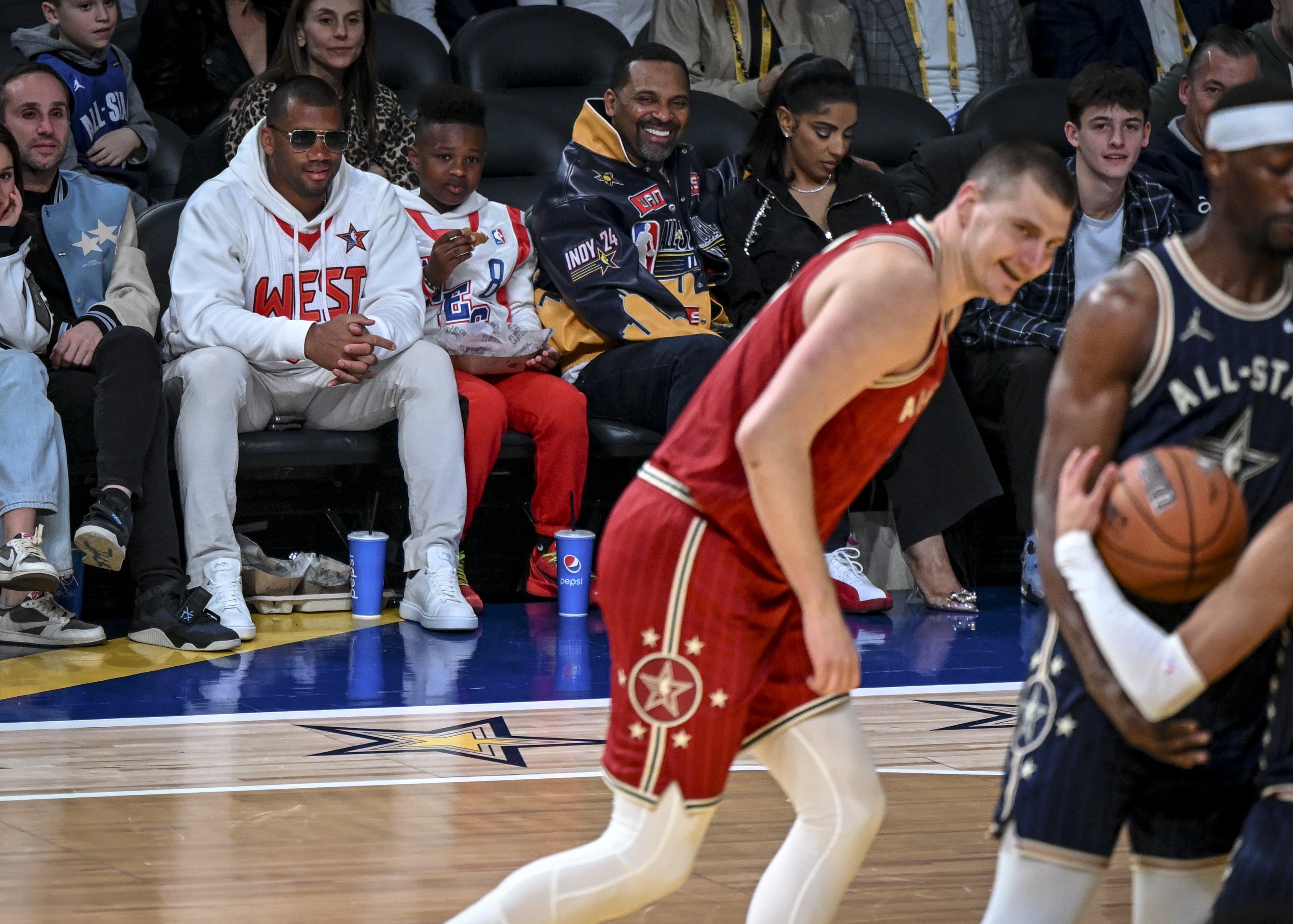 Nikola Jokic (15) of the Denver Nuggets entertains Denver Broncos quarterback Russell Wilson, Future Jr., and entertainer Mike Epps after faking a dunk before lightly laying the ball in during the NBA All-Star game at Gainbridge Fieldhouse in Indianapolis, Indiana on Sunday, Feb. 18, 2024. (Photo by AAron Ontiveroz/The Denver Post)