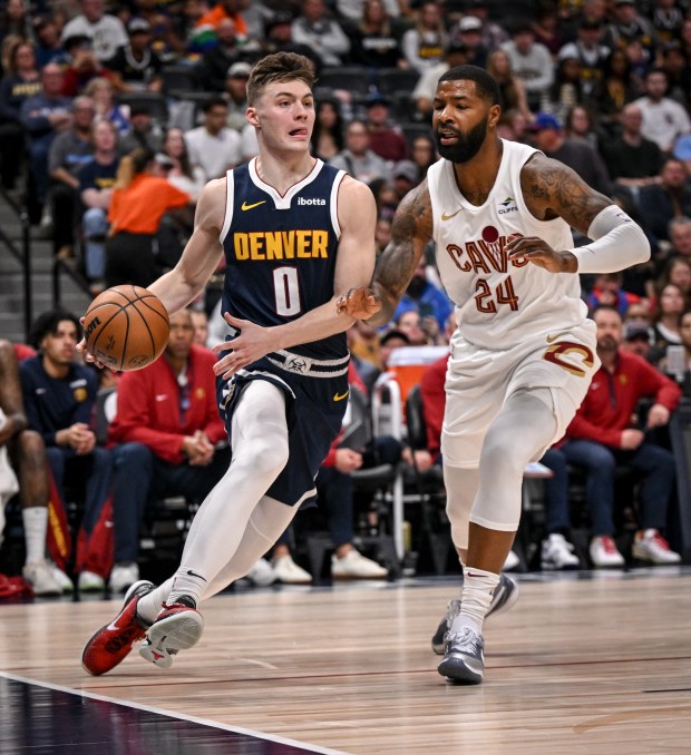 Christian Braun (0) of the Denver Nuggets drives on Marcus Morris Sr. (24) of the Cleveland Cavaliers during the second quarter at Ball Arena in Denver on Sunday, March 31, 2024. (Photo by AAron Ontiveroz/The Denver Post)