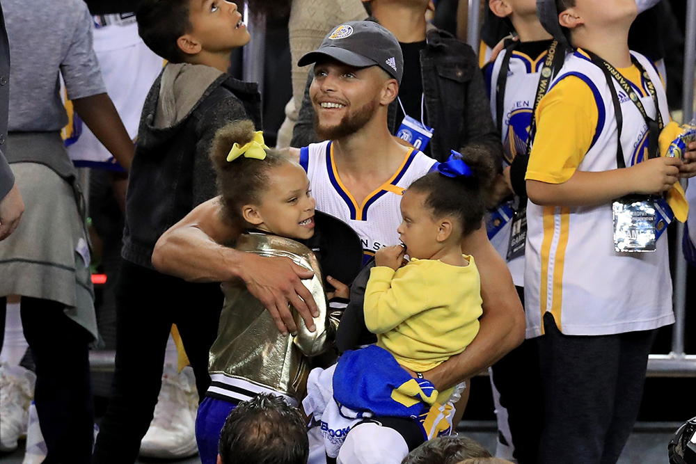 Steph Curry holding his two daughters.