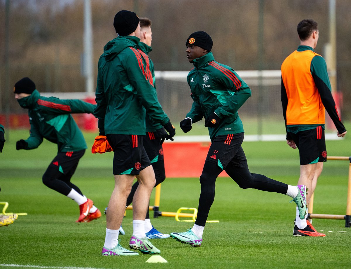 Kobbie Mainoo and the Reds warm up for training at Carrington.