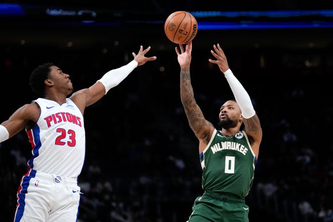 Người bảo vệ Milwaukee Bucks Damian Lillard (0) sút vào người bảo vệ Detroit Pistons Jaden Ivey (23) trong hiệp một.