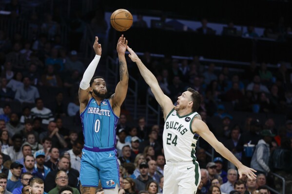 Charlotte Hornets forward Miles Bridges (0) shoots over Milwaukee Bucks guard Pat Connaughton (24) during the first half of an NBA basketball game in Charlotte, N.C., Thursday, Feb. 29, 2024. (AP Photo/Nell Redmond)