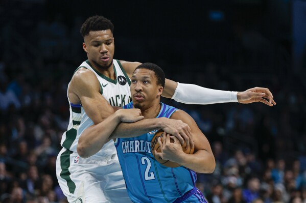 Charlotte Hornets forward Grant Williams, right, is fouled as he drives against Milwaukee Bucks forward Giannis Antetokounmpo, left, during the first half of an NBA basketball game in Charlotte, N.C., Thursday, Feb. 29, 2024. (AP Photo/Nell Redmond)