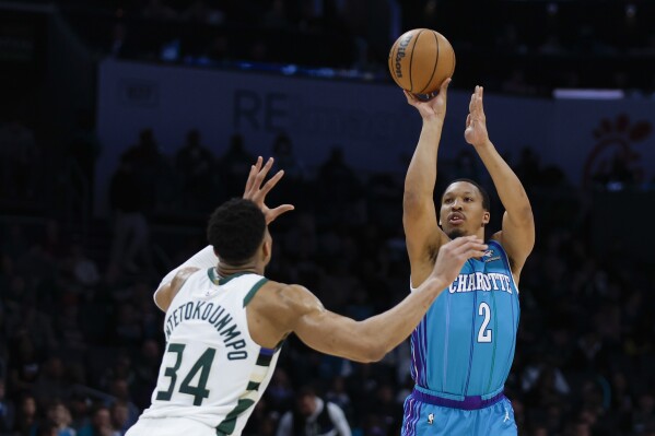 Charlotte Hornets forward Grant Williams (2) shoots over Milwaukee Bucks forward Giannis Antetokounmpo (34) during the first half of an NBA basketball game in Charlotte, N.C., Thursday, Feb. 29, 2024. (AP Photo/Nell Redmond)