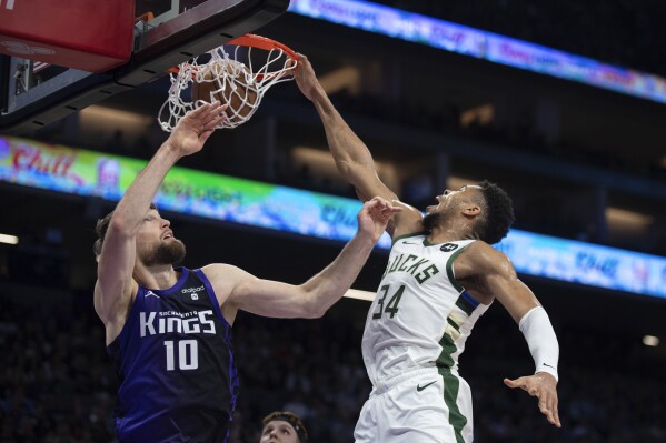 Tiền đạo Giannis Antetokounmpo (34) của Milwaukee Bucks ghi bàn trước tiền đạo Domantas Sabonis (10) của Sacramento Kings trong hiệp đầu tiên của một trận đấu bóng rổ NBA ở Sacramento, California, Thứ Ba, ngày 12 tháng 3 năm 2024. (Ảnh AP / Jose Luis Villegas)