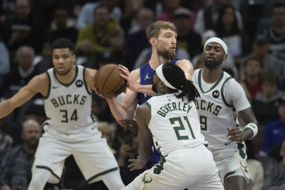 Sacramento Kings forward Domantas Sabonis (10) is surrounded by Milwaukee Bucks guard Patrick Beverley (21), forward Bobby Portis (9) and forward Giannis Antetokounmpo (34) in the first quarter of an NBA basketball game in Sacramento, Calif., Tuesday, March 12, 2024. (AP Photo/José Luis Villegas)