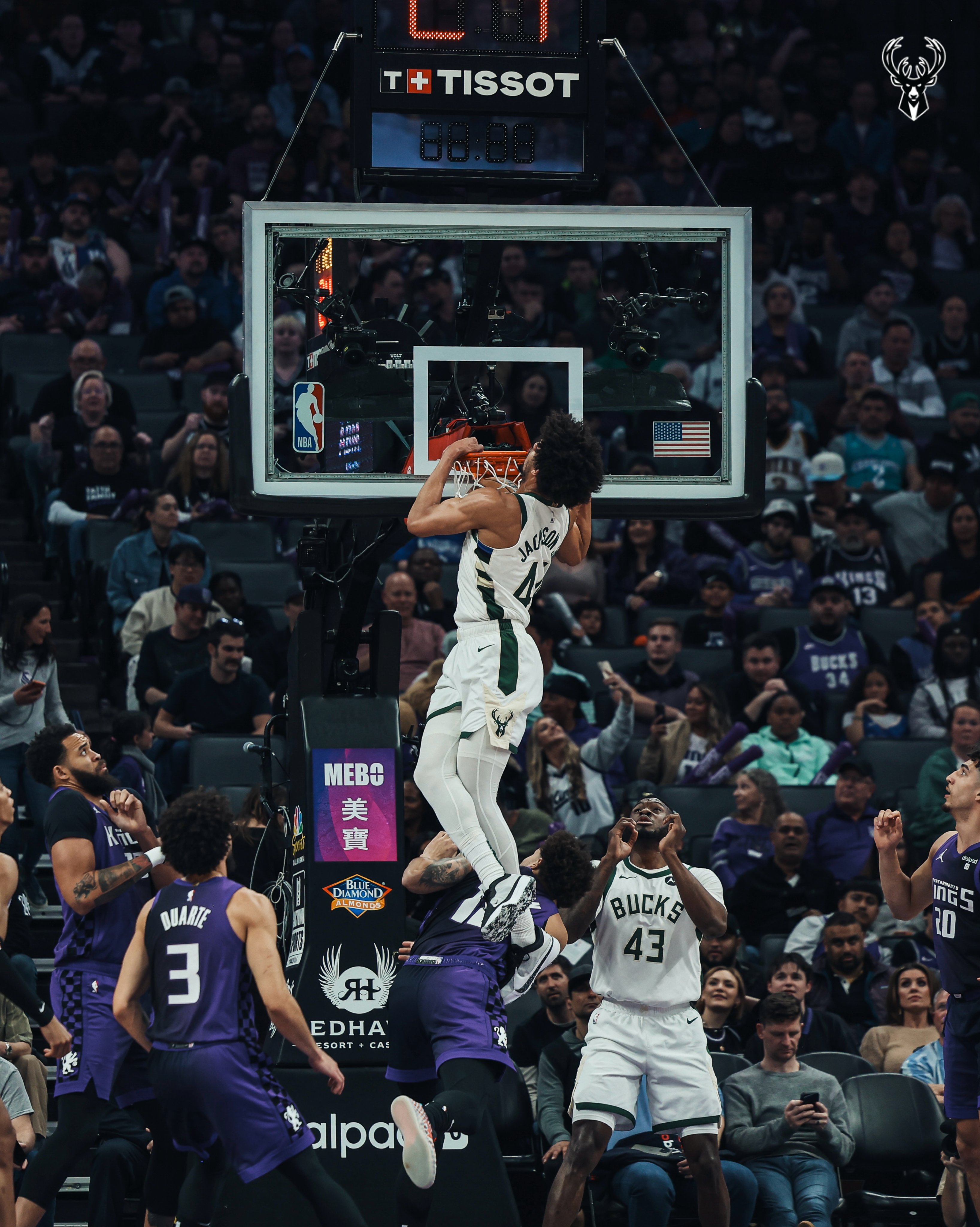 A photo of Andre Jackson Jr. finishing a putback slam with his head at the rim.