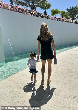 Brittany and Sterling walking by a body of clear water