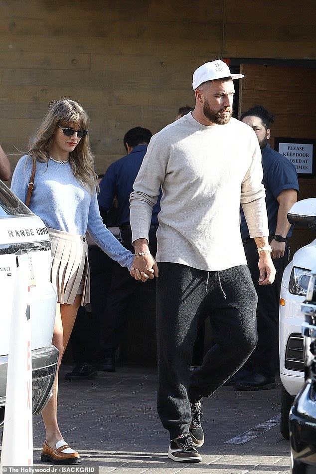 Meanwhile Travis was casual cool, sporting an off-white long-sleeve top, black sweatpants and a white hat