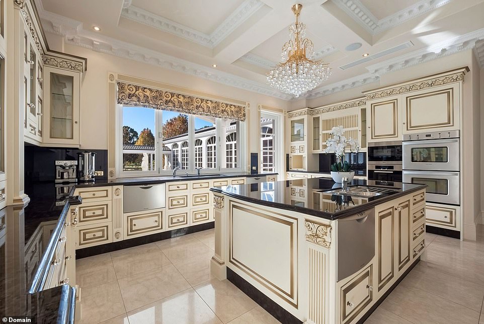 The kitchen includes all the modern luxuries from the gourmet appliances and a walk-in cool room but still features nods to the home's signature style through the gold detailing on the cabinetry and mini crystal light pendant