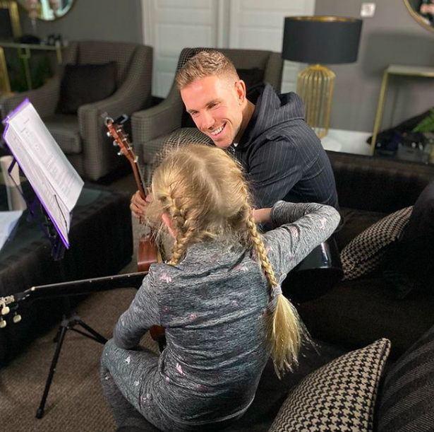 The living room is chic and cosy and the father-of-three shares a moment with one of his daughters