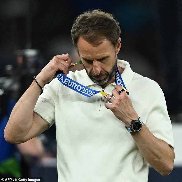 Southgate pictured removing his runners-up medal after Sunday's disappointing defeat