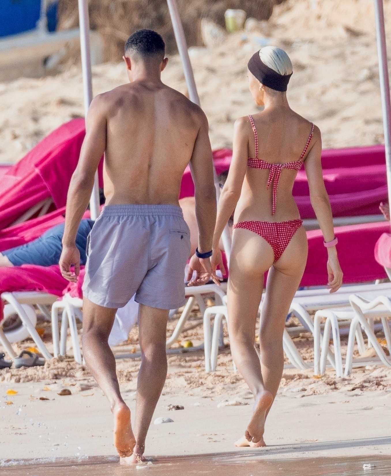 The couple soaked up the sun as they enjoyed a walk on the beach