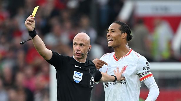 MANCHESTER, ENGLAND - SEPTEMBER 01: Referee Anthony Taylor shows a yellow card to Lisandro Martinez of Manchester United (not pictured) as he holds off Virgil van Dijk during the Premier League match between Manchester United FC and Liverpool FC at Old Trafford on September 01, 2024 in Manchester, England. (Photo by Shaun Botterill/Getty Images)